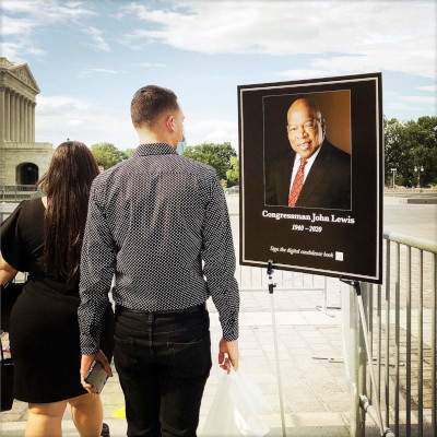 Visitors passing by look at a picture of John Lewis as his body lay in state at the U.S. Capitol, July 2020, Washington, D.C.