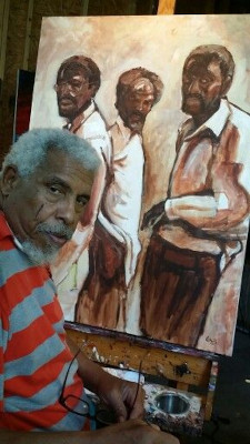 Arthur "Art" Bacon sitting at an easel with his painting of three African American men.