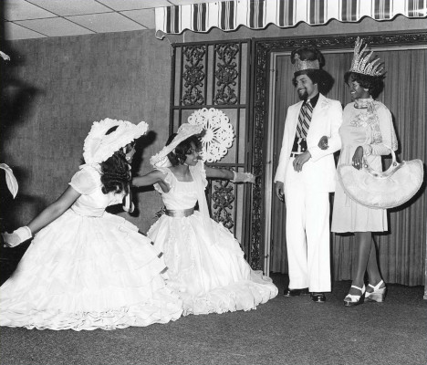 Azalea Trail Maids greet King Elixis I, Walker "Champ" Beck LeFlore Jr., and his Queen, Winifred Lucy, to MAMGA's 1975 luncheon held at the Quality Inn.