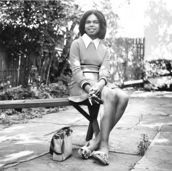 Condoleezza Rice sitting on a bench outside at the University of Denver as an undergraduate