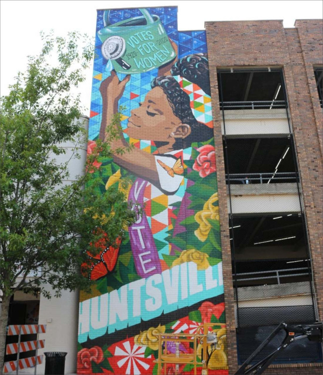 3-story mural in Huntsville, Alabama by Nashville-based artist Kimberly Radford, celebrating the 100th anniversary of the 19th Amendment (women's suffrage); depicts a young African American girl reaching high to water a nearby tree growing on Washington Street