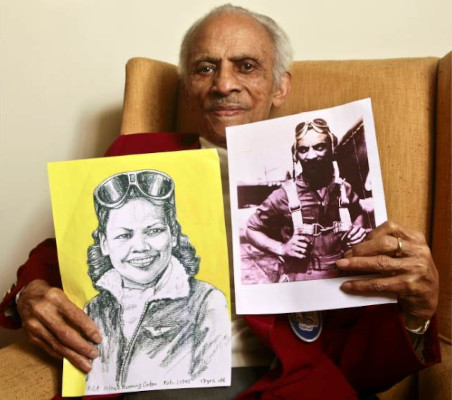 Herbert Carter holds a portrait of his wife Mildred Hemmons Carter and a photograph of himself from their flying days.