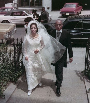 Elizabeth Mance wears an Ann Lowe design in a wedding photograph, circa 1968. Lowe can be seen behind the bride and her father being escorted to the church.