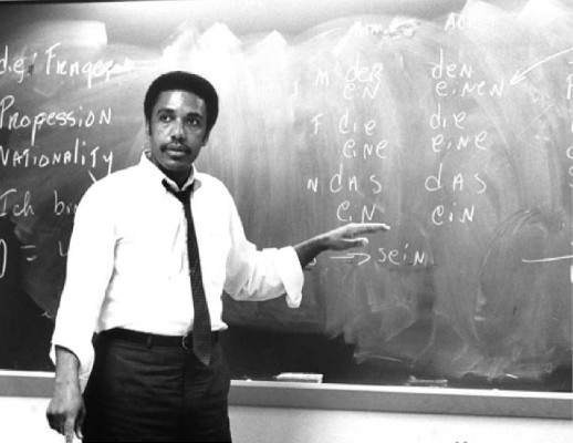 James E. McLeod directing attention to the chalkboard in a classroom