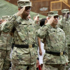 A group of soldiers, including A.C. Roper, saluting.